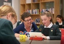 Teacher working with student on tablet