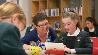 Teacher working with student on tablet