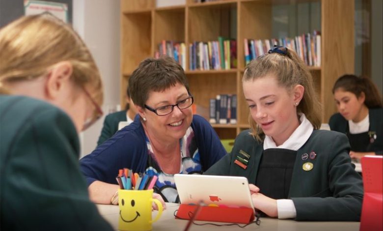 Teacher working with student on tablet