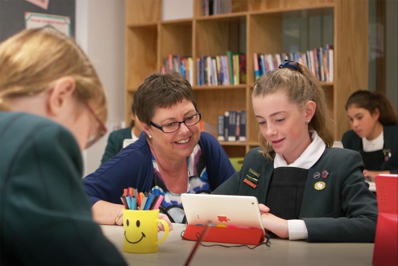 Teacher working with student on tablet