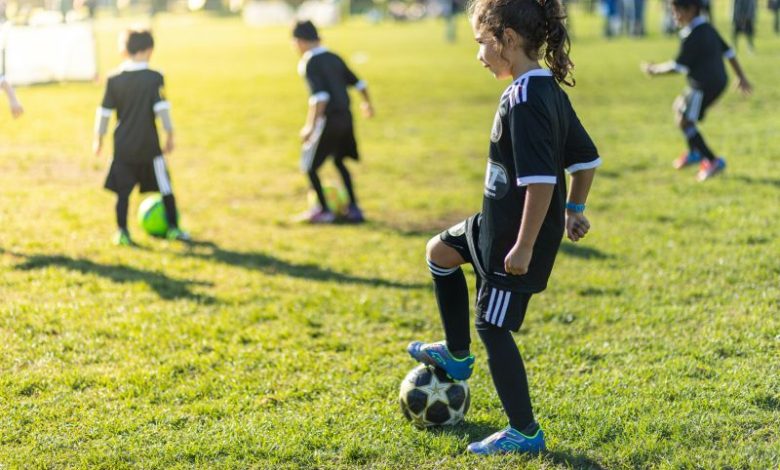 Young female student with soccer ball