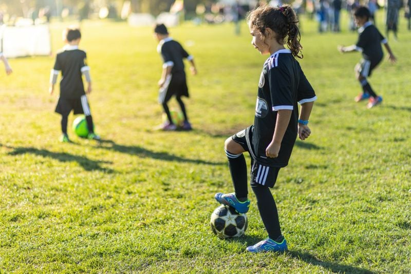 Young female student with soccer ball